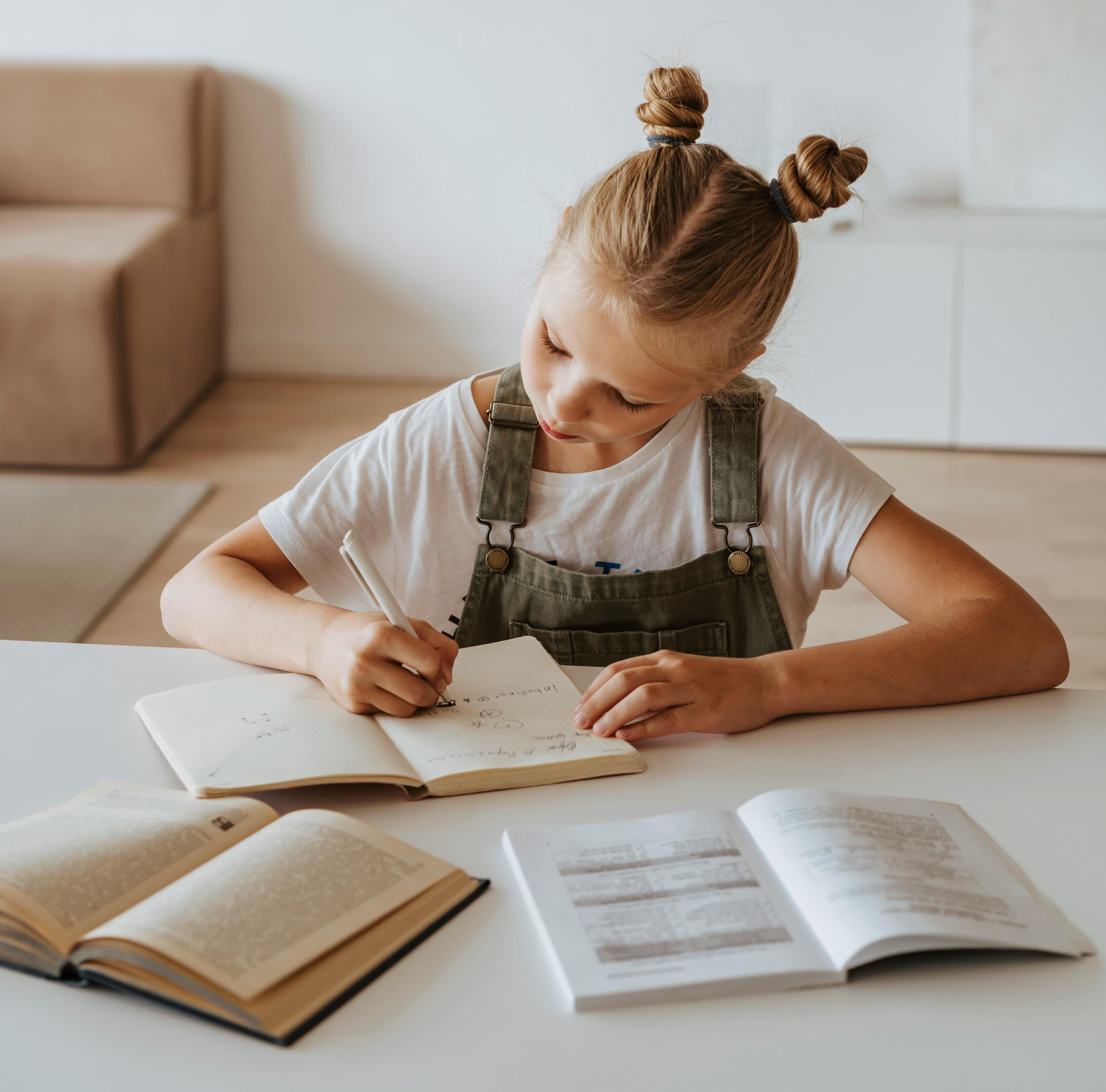 Elementary girl practicing reading comprehension skills by writing notes at home