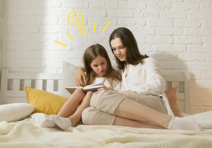 Mother and daughter reading together on a bed