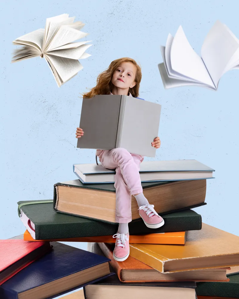 Girl reading on top of a tall stack of books