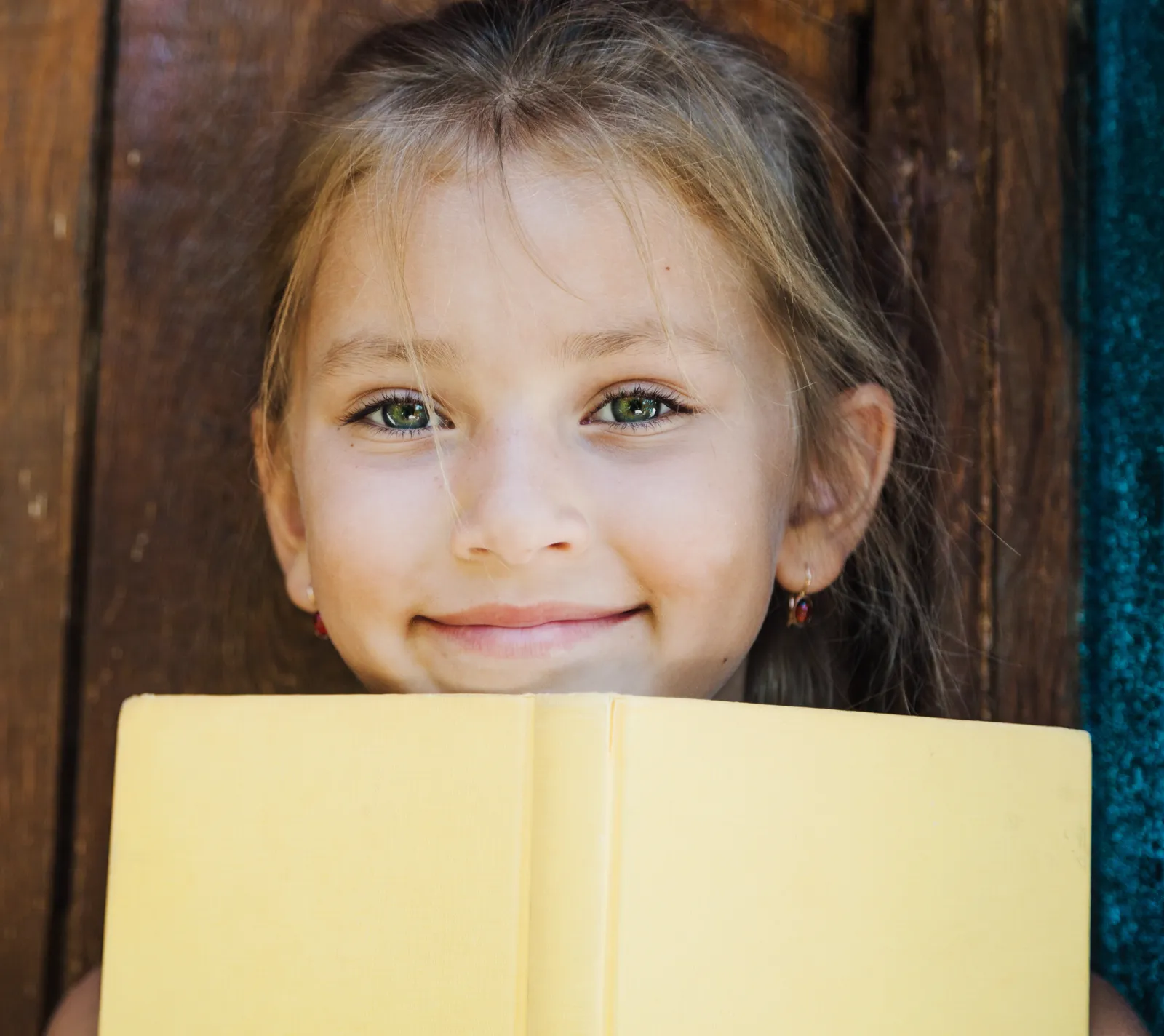 Smiling girl holding a yellow book