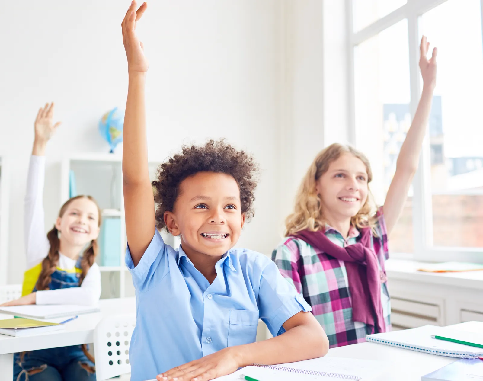 Students raising their hands in a classroom