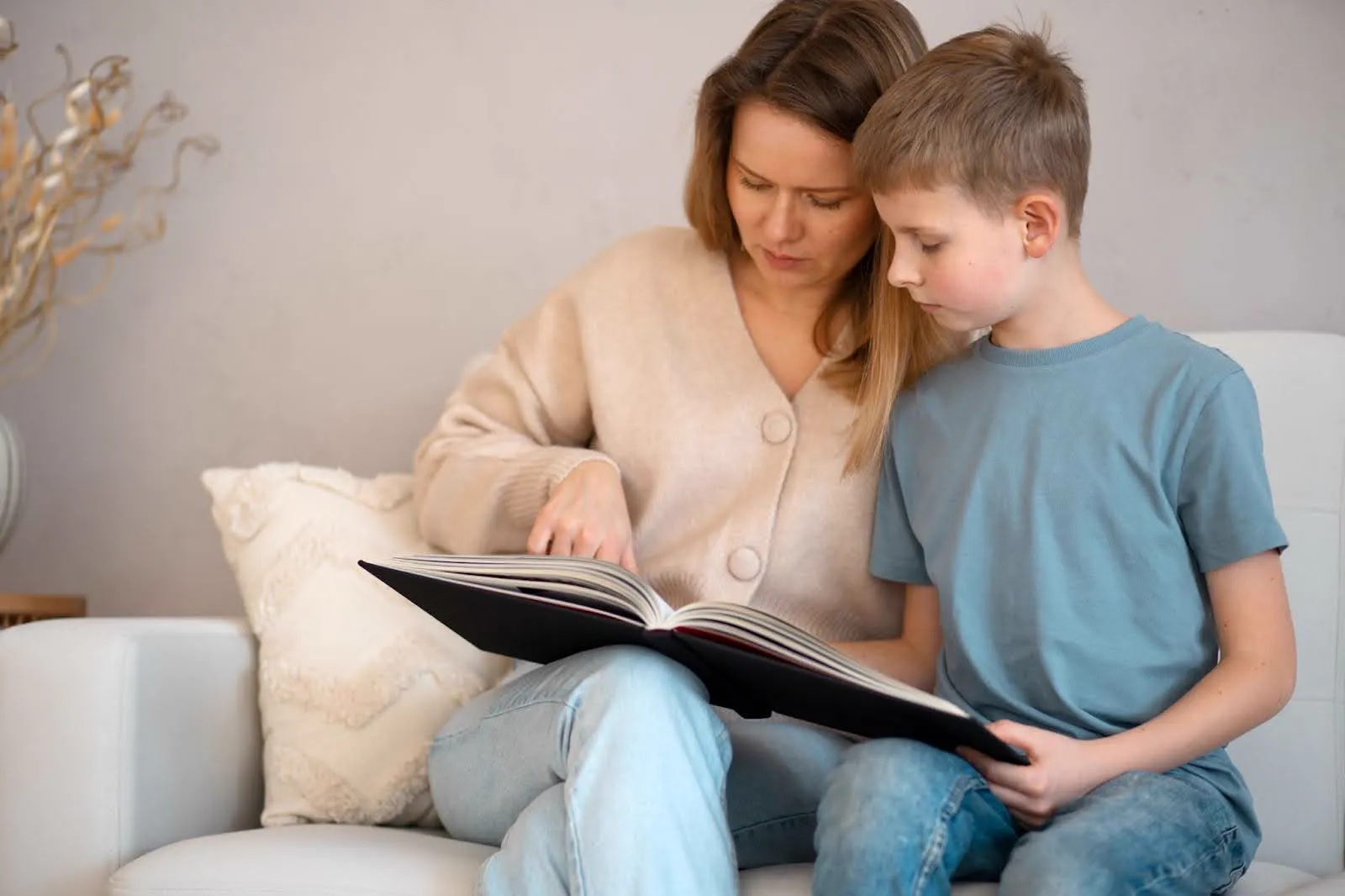 Mother helping her child read a book, creating a supportive environment for overcoming reading anxiety.